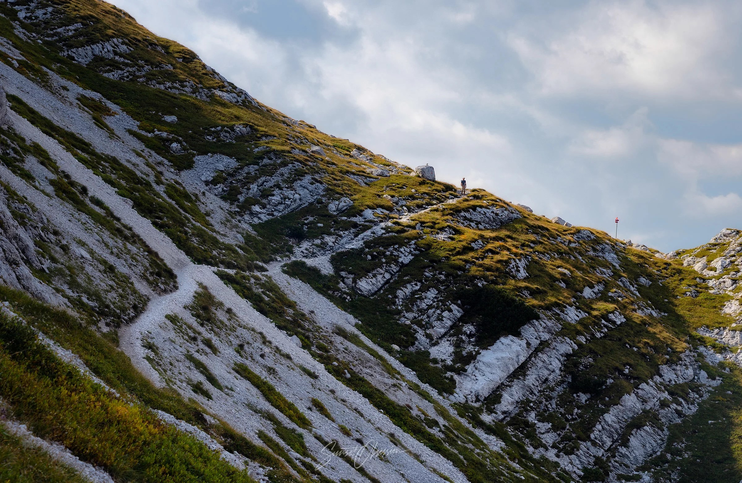 A lonely hiker near Vratca Saddle at Mount Vogel hike in Triglav National Park